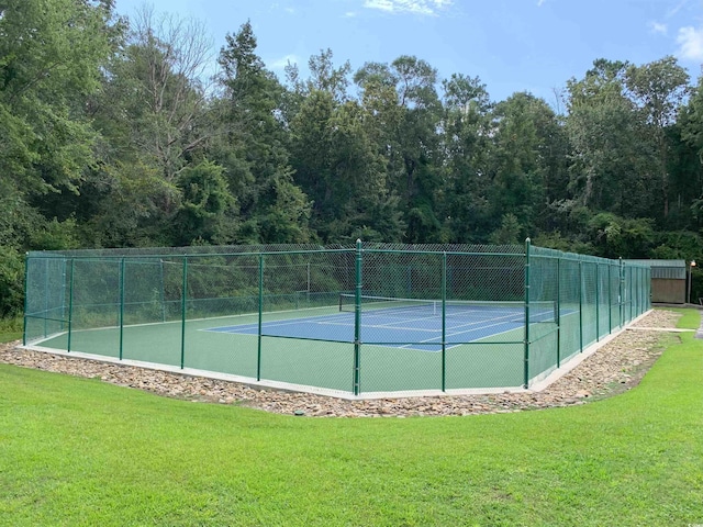 view of tennis court with a yard