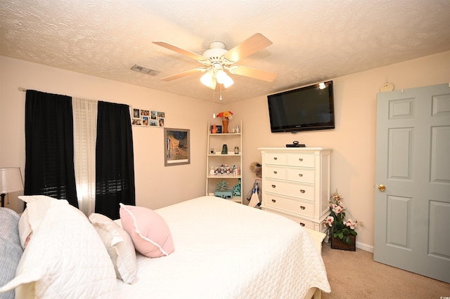 carpeted bedroom featuring a textured ceiling and ceiling fan