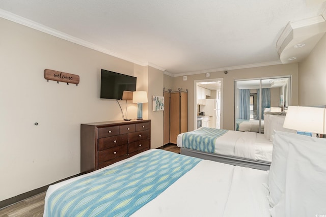 bedroom featuring hardwood / wood-style floors, connected bathroom, a closet, and ornamental molding