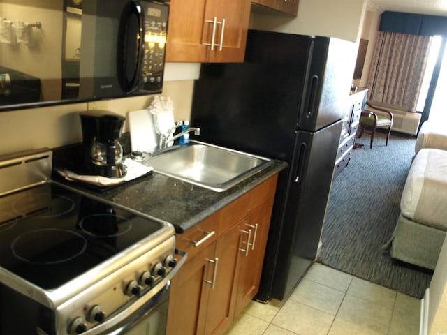 1200 N Ocean Blvd Unit 804, Myrtle Beach, SC 29577 - kitchen with black appliances, a sink, brown cabinets, dark countertops, and light tile patterned flooring