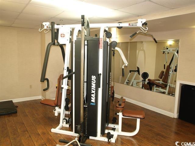 1200 N Ocean Blvd Unit 804, Myrtle Beach, SC 29577 - exercise room featuring a drop ceiling, baseboards, and wood-type flooring