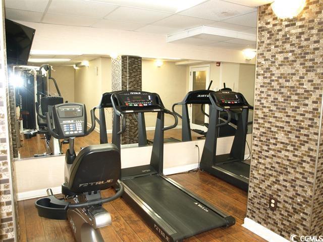 1200 N Ocean Blvd Unit 804, Myrtle Beach, SC 29577 - workout area with a paneled ceiling, hardwood / wood-style floors, and baseboards