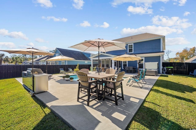 view of patio featuring an outdoor kitchen and a fenced in pool