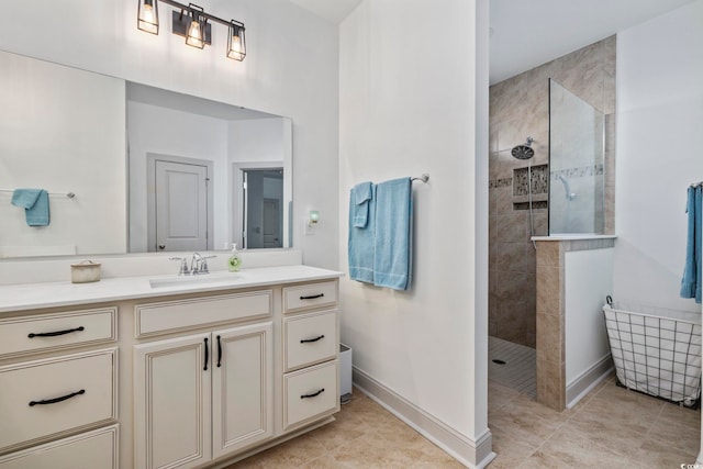 bathroom featuring tile patterned flooring, vanity, and tiled shower