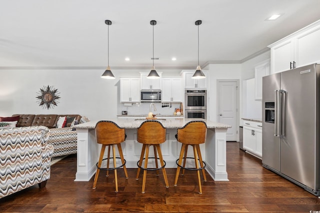 kitchen featuring white cabinets, an island with sink, appliances with stainless steel finishes, decorative light fixtures, and dark hardwood / wood-style flooring