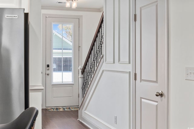 doorway to outside featuring crown molding and dark wood-type flooring