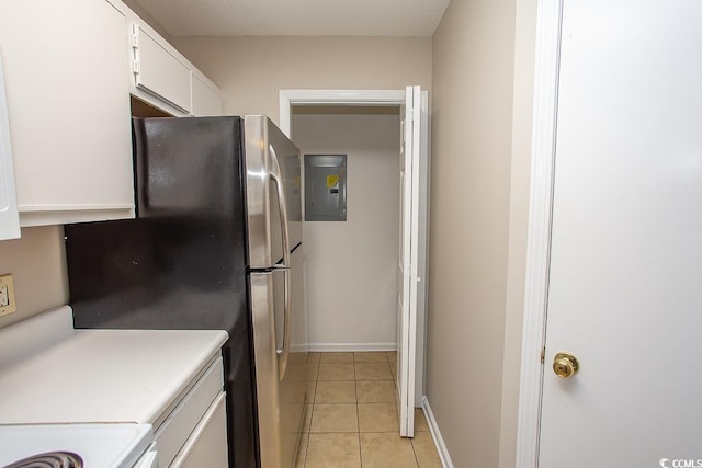 kitchen with stainless steel refrigerator, electric panel, white cabinets, and light tile patterned flooring