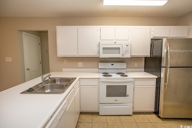 kitchen with kitchen peninsula, white appliances, sink, white cabinetry, and light tile patterned flooring