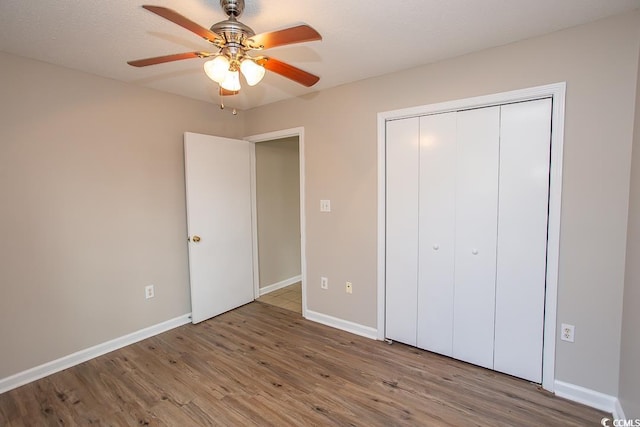 unfurnished bedroom featuring hardwood / wood-style floors, a textured ceiling, a closet, and ceiling fan