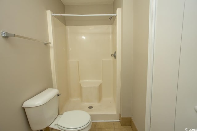 bathroom with toilet, tile patterned floors, and walk in shower