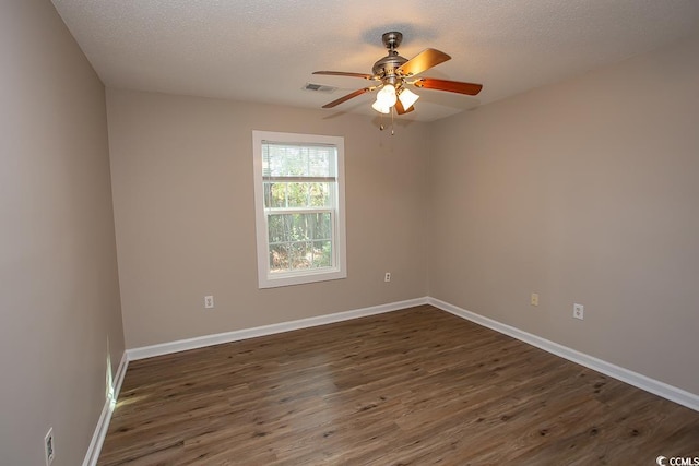 empty room featuring a textured ceiling, ceiling fan, and dark wood-type flooring