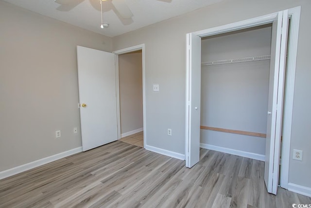 unfurnished bedroom with a textured ceiling, a closet, light hardwood / wood-style floors, and ceiling fan