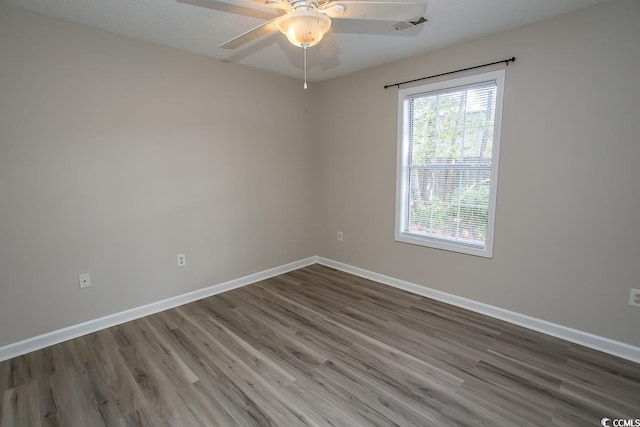 empty room with hardwood / wood-style floors and ceiling fan