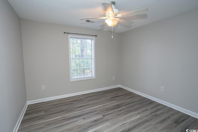 empty room featuring a textured ceiling, ceiling fan, and dark hardwood / wood-style floors