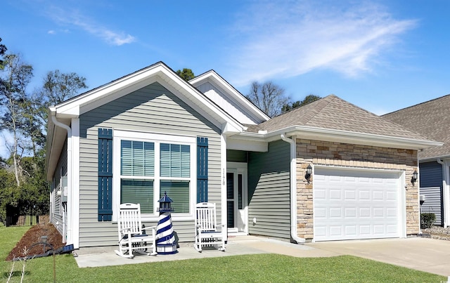 view of front of home featuring an attached garage, stone siding, a shingled roof, and concrete driveway