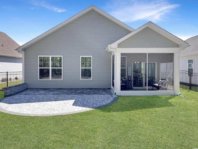 back of property featuring a sunroom, a patio area, a lawn, and fence