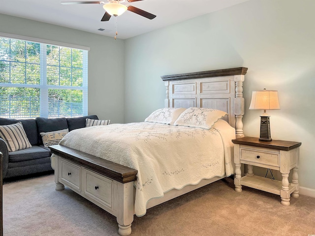 bedroom featuring light carpet, ceiling fan, visible vents, and baseboards