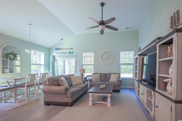 living room featuring ceiling fan with notable chandelier, lofted ceiling, and light hardwood / wood-style flooring