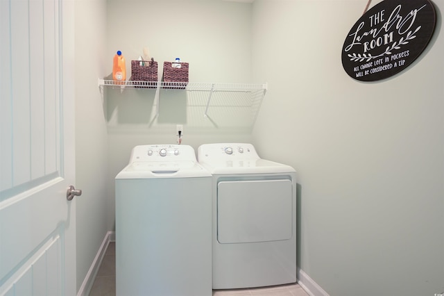 washroom with laundry area, independent washer and dryer, baseboards, and tile patterned floors