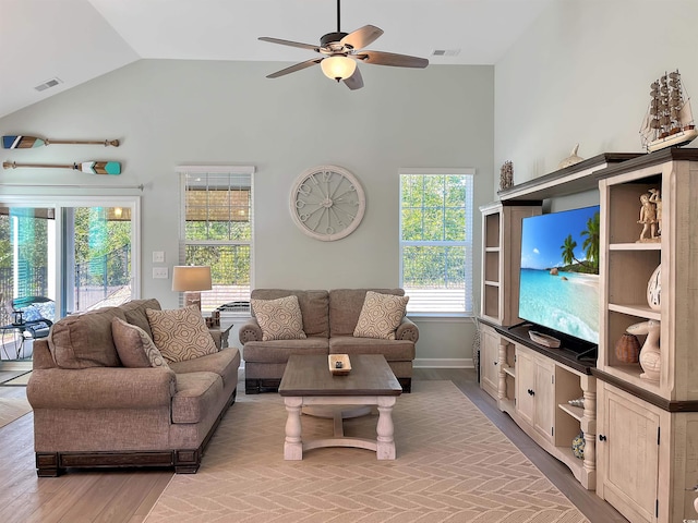 living area featuring ceiling fan, vaulted ceiling, visible vents, and baseboards