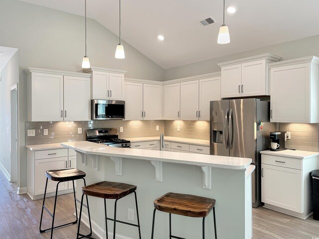 kitchen featuring stainless steel refrigerator with ice dispenser, light wood-type flooring, white cabinetry, and an island with sink