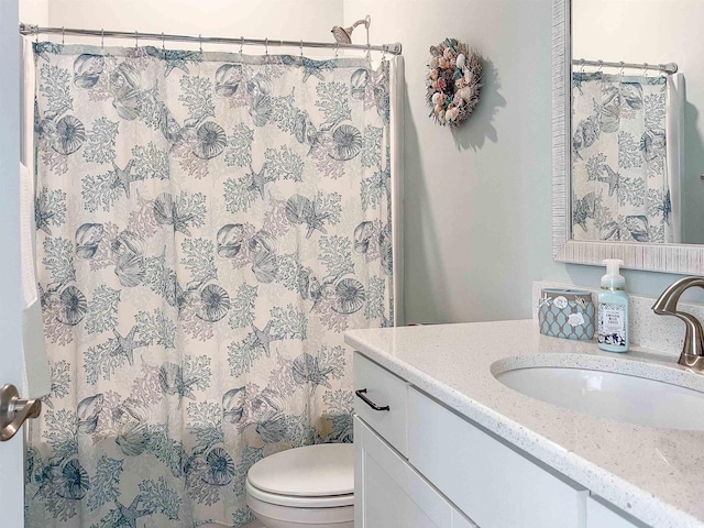 bathroom featuring a shower with shower curtain, vanity, and toilet