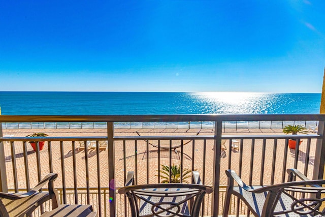 balcony featuring a water view and a view of the beach