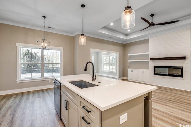 kitchen with a healthy amount of sunlight, sink, hanging light fixtures, and a kitchen island with sink