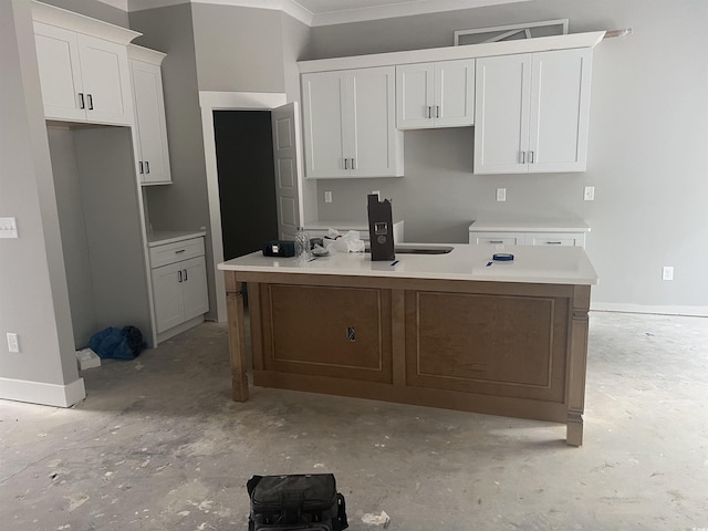 kitchen with crown molding, white cabinetry, and a kitchen island