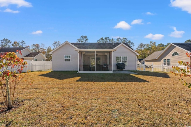 rear view of property with a lawn and a sunroom