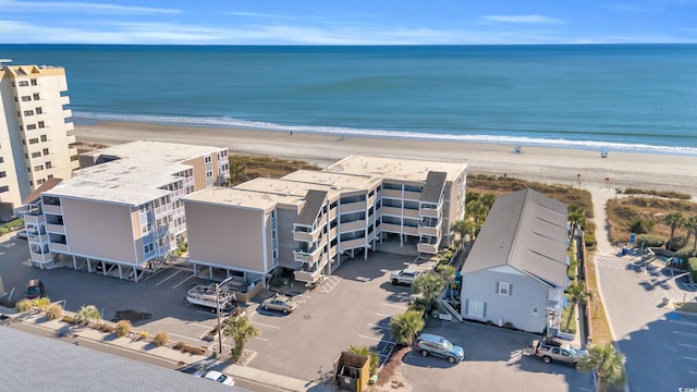 birds eye view of property with a water view and a beach view