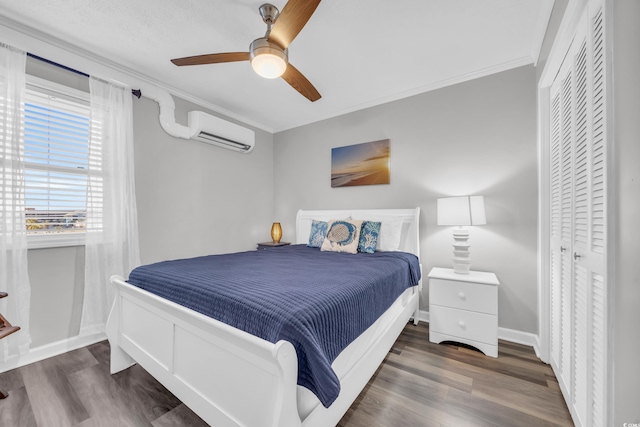 bedroom featuring dark wood-type flooring, ornamental molding, a wall unit AC, and ceiling fan