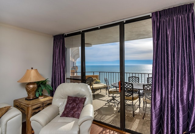 living area with floor to ceiling windows, a water view, ornamental molding, and a wealth of natural light