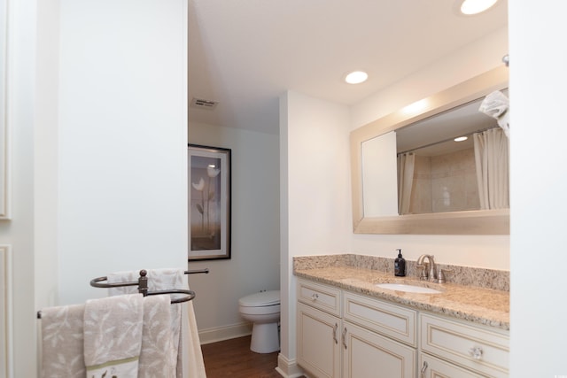 bathroom featuring vanity, toilet, and wood-type flooring