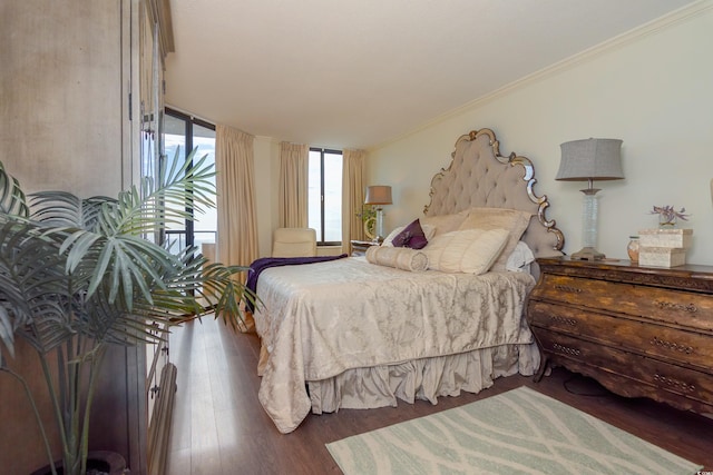 bedroom featuring a wall of windows, ornamental molding, and dark wood-type flooring