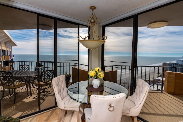 sunroom with plenty of natural light and a water view