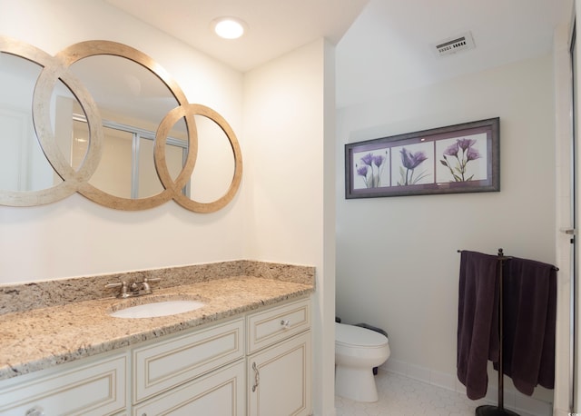 bathroom featuring tile patterned floors, vanity, and toilet