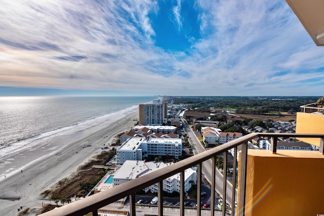 balcony with a water view and a view of the beach