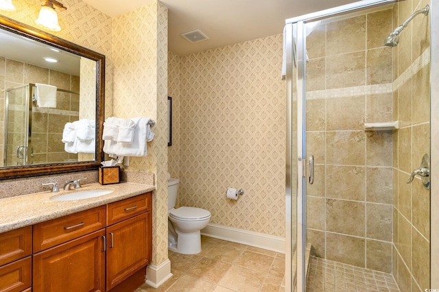 bathroom featuring tile patterned flooring, vanity, toilet, and an enclosed shower