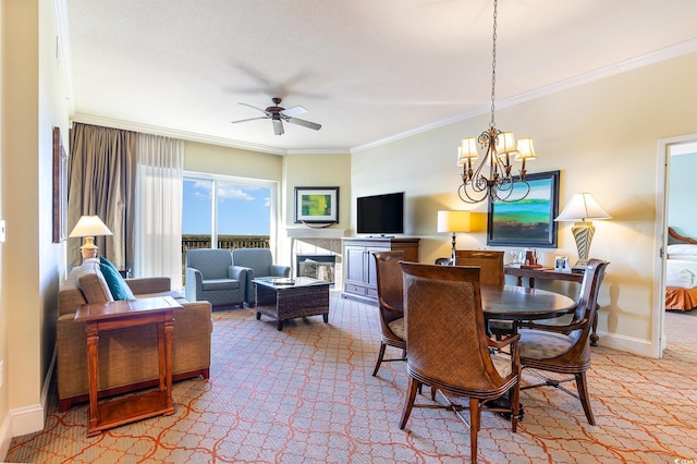 dining space with carpet, ceiling fan with notable chandelier, ornamental molding, and a fireplace