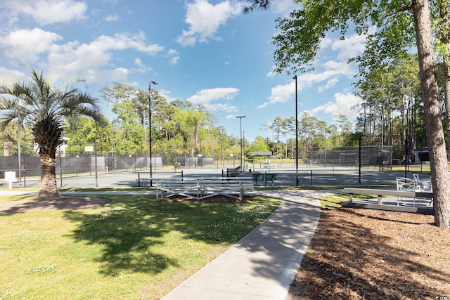 view of home's community featuring tennis court and a yard