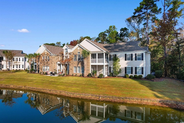 view of front of house featuring a water view, a front lawn, and a sunroom