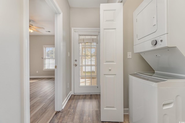 washroom with wood-type flooring, ceiling fan, and stacked washer and clothes dryer