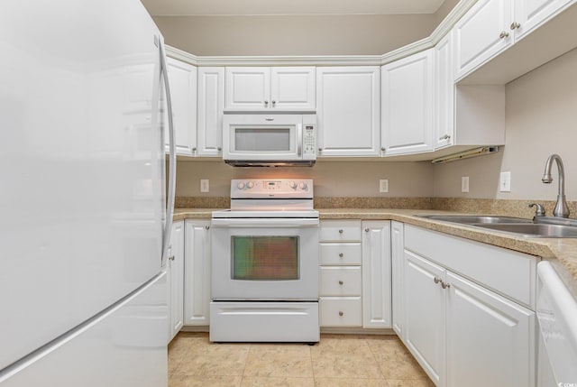 kitchen featuring white appliances, white cabinetry, sink, and light tile patterned floors