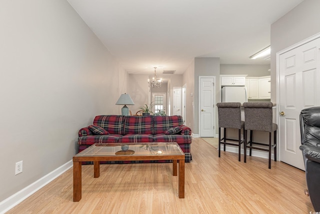 living room featuring a chandelier and light hardwood / wood-style floors