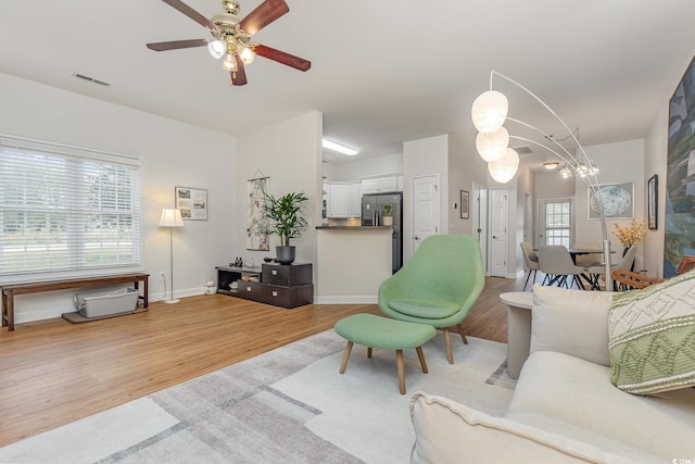 living room featuring light wood-type flooring and ceiling fan