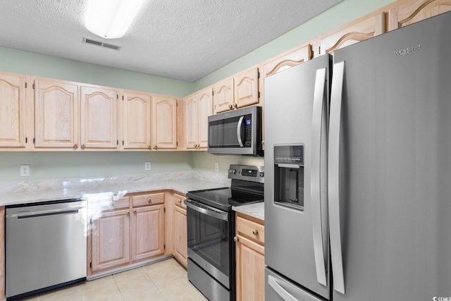 kitchen featuring a textured ceiling, light tile patterned flooring, stainless steel appliances, and light brown cabinetry