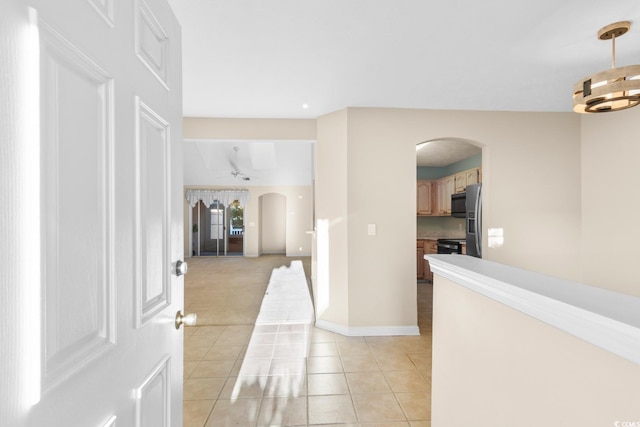 corridor with a chandelier and light tile patterned floors