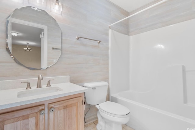 full bathroom with vanity, bathing tub / shower combination, tile patterned floors, toilet, and tile walls