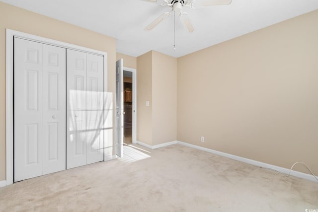 unfurnished bedroom with ceiling fan, a closet, and light colored carpet